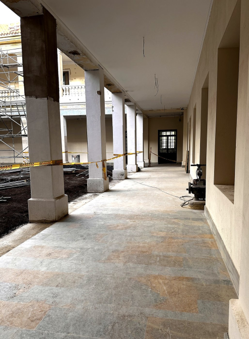 Pasillo de La Facultad con enchape en Royal Veta. La combinación de anchos de 10, 20 y 30 cm en junta perdida produce un patrón irregular que acompaña la arquitectura sin imitarla.